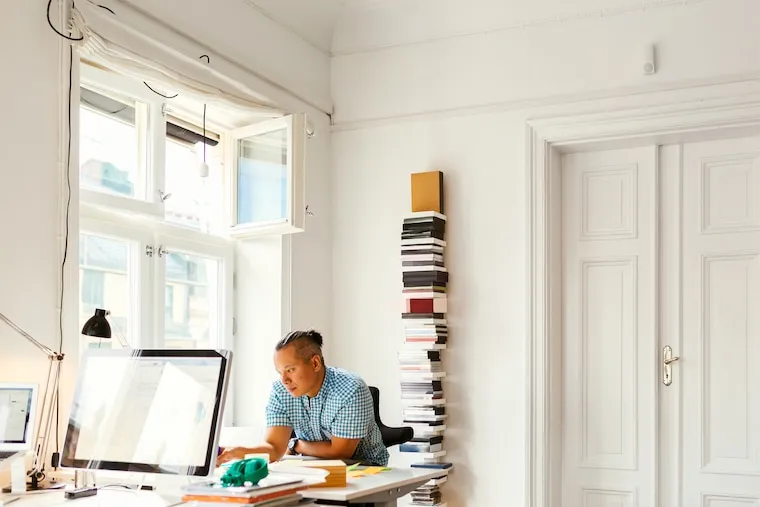 A modern accounting office with glass-walled meeting rooms and desks near large windows, in a natural documentary style.