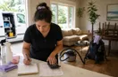 A cleaning business owner calculating an itemized quote at a counter with a notebook, in a natural documentary style.
