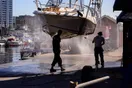 A pressure washing business owner training a new technician on soft-wash equipment beside a work truck, natural documentary style.