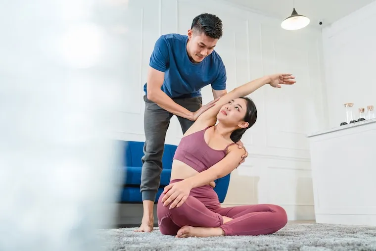 A studio owner reviewing a class schedule with a yoga teacher at a reception desk, natural documentary lighting.