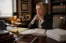 An attorney reviewing invoices and a ledger at a desk in late-afternoon light, in a natural documentary style.