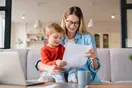 A daycare director reviewing an enrollment and profit-and-loss report at an office desk, in a natural documentary style.