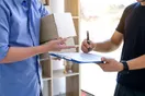 A delivery business owner reviewing route earnings and expenses on a laptop in a parked van, in a natural documentary style.