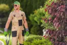 A landscaping crew working a maintenance route with commercial mowers on a residential property, representing recurring revenue, in a natural documentary style.
