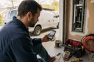 An electrician checking a social feed on a phone at the job site, in a natural documentary style.