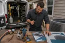 marketing materials, business cards, and a yard sign laid out on a workbench, in a natural documentary style.