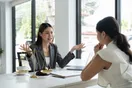 A lawyer shaking hands with a new client across a desk in a law office, in a natural documentary style.