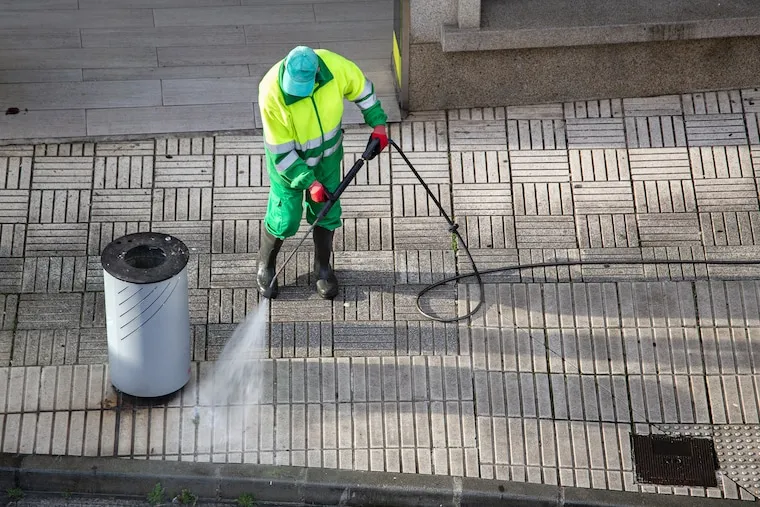 A pressure washing operator hanging a door-hanger flyer on a suburban front door with a work truck at the curb, in a natural documentary style.