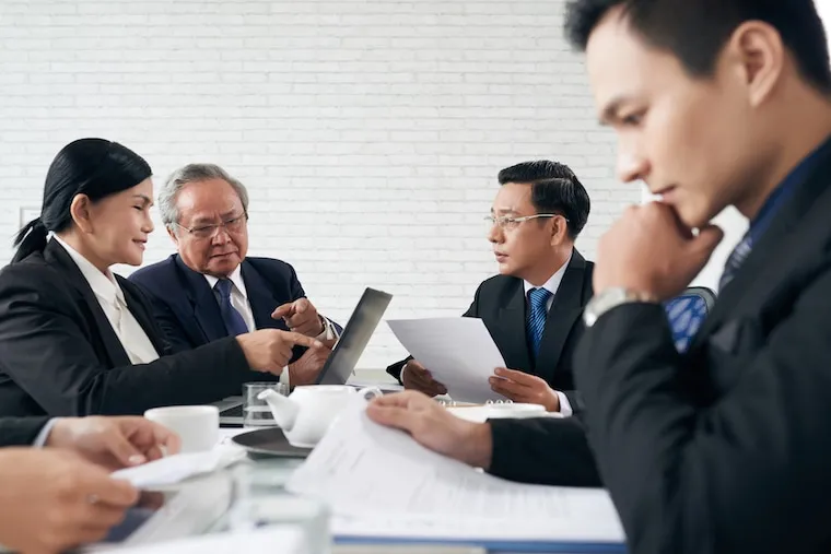 A small legal team working together around a conference table in a law office, in a natural documentary style.