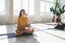 A yoga teacher trainer leading a small group through a pose breakdown during a weekend training, documentary style.
