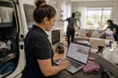 A cleaning business owner reviewing a website mock-up on a laptop at the work site, in a natural documentary style.