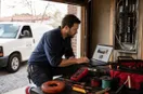 An electrician reviewing a website mock-up on a laptop at the work site, in a natural documentary style.