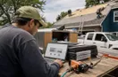 A roofing contractor reviewing a website mock-up on a laptop at the work site, in a natural documentary style.