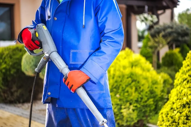 A pressure washing company logo displayed on the door of a work truck parked in a driveway, in a natural documentary style.