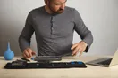 A phone repair website open on a laptop next to a disassembled smartphone on a workbench, documentary style.