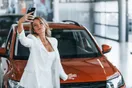 A phone filming a vertical walkaround video of a car on a dealership lot, shown in a natural documentary style.