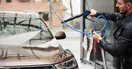 A car being filmed on a smartphone gimbal as it moves through a tunnel car wash, in a natural documentary style.
