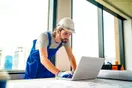 A homeowner searching for a general contractor on Google Maps on a laptop, with a construction company profile and reviews visible, in a natural documentary style.