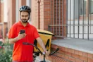 A delivery driver filming a short vertical video of a package handoff on a phone, in a natural documentary style.