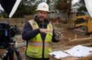 A site contractor explaining a technique to an off-frame camera in the workshop, in a natural documentary style.