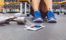 A trainer recording a quick form-tip video on a phone tripod on the gym floor, in a natural documentary style.