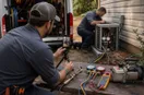 A phone on a small tripod filming an HVAC technician at work, in a natural documentary style.