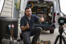 An HVAC technician explaining a technique to an off-frame camera in the workshop, in a natural documentary style.