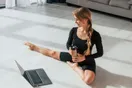 A yoga instructor filming a short class clip on a phone tripod in a sunlit studio, documentary style.