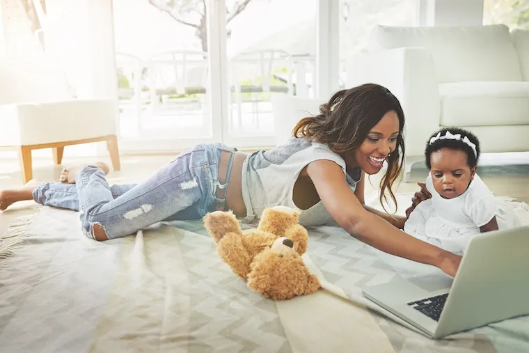 A parent on a laptop searching for local daycare with a Google results page visible, home setting, documentary style.