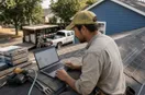 A roofing contractor studying an ads dashboard with charts on a laptop, in a natural documentary style.