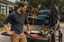 A junk removal operator unlocking the door of a small shop for the first time at golden hour, in a natural documentary style.