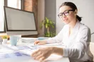 An accountant reviewing financial statements and charts across two monitors in a professional office, documentary style.