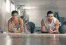 A gym owner studying a membership and revenue spreadsheet on a monitor in a quiet studio, in a natural documentary style.