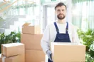 A moving crew loading furniture into a large box truck outside an apartment building, in a natural documentary style.