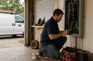 An electrician coordinating the day's schedule at a small dispatch desk, in a natural documentary style.