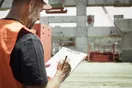 A contractor loading tools into a work pickup truck outside a residential job site, in a natural documentary style.