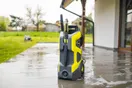 Pressure washing equipment laid out including a gas machine, surface cleaner, hose reel, and colored nozzles, natural documentary style.